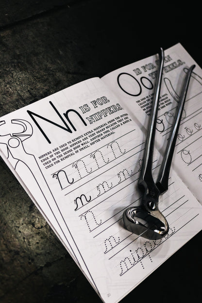 Inside page of the farrier cursive workbook. Showing the nippers page with actual nippers. 